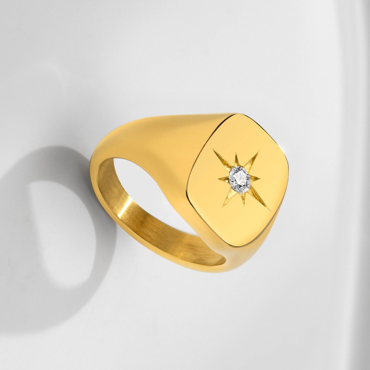 Gold ring with a diamond on a light gray background