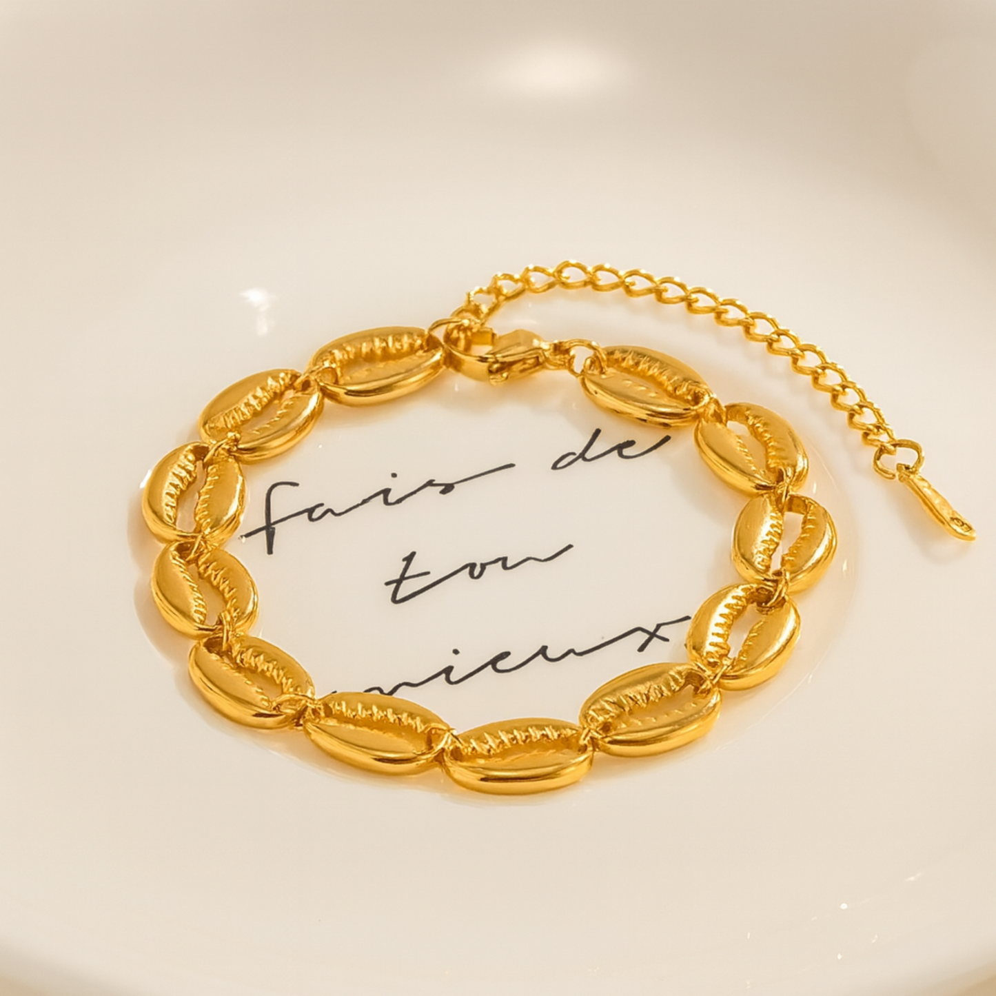 Gold bracelet on a light background with cursive text