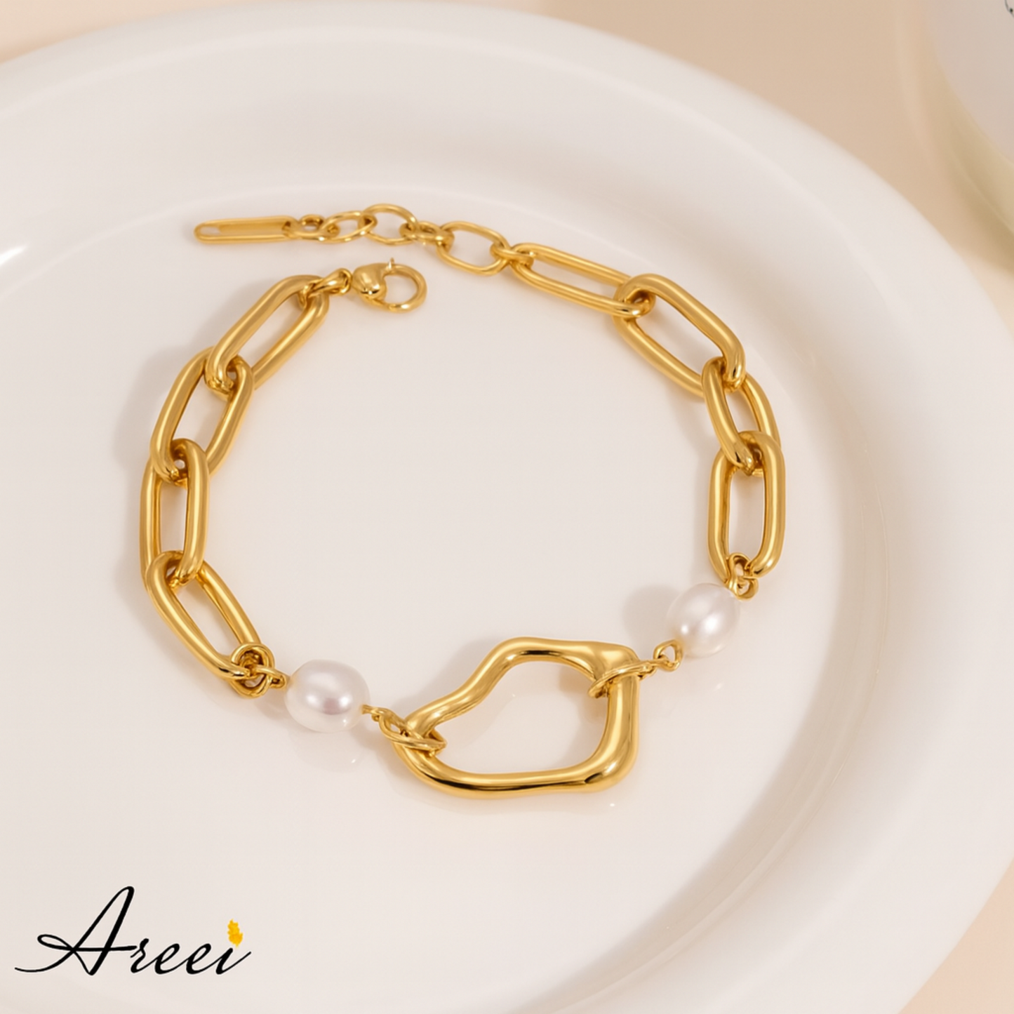 Gold chain bracelet with pearls on a white plate, featuring the brand 'Areei'.