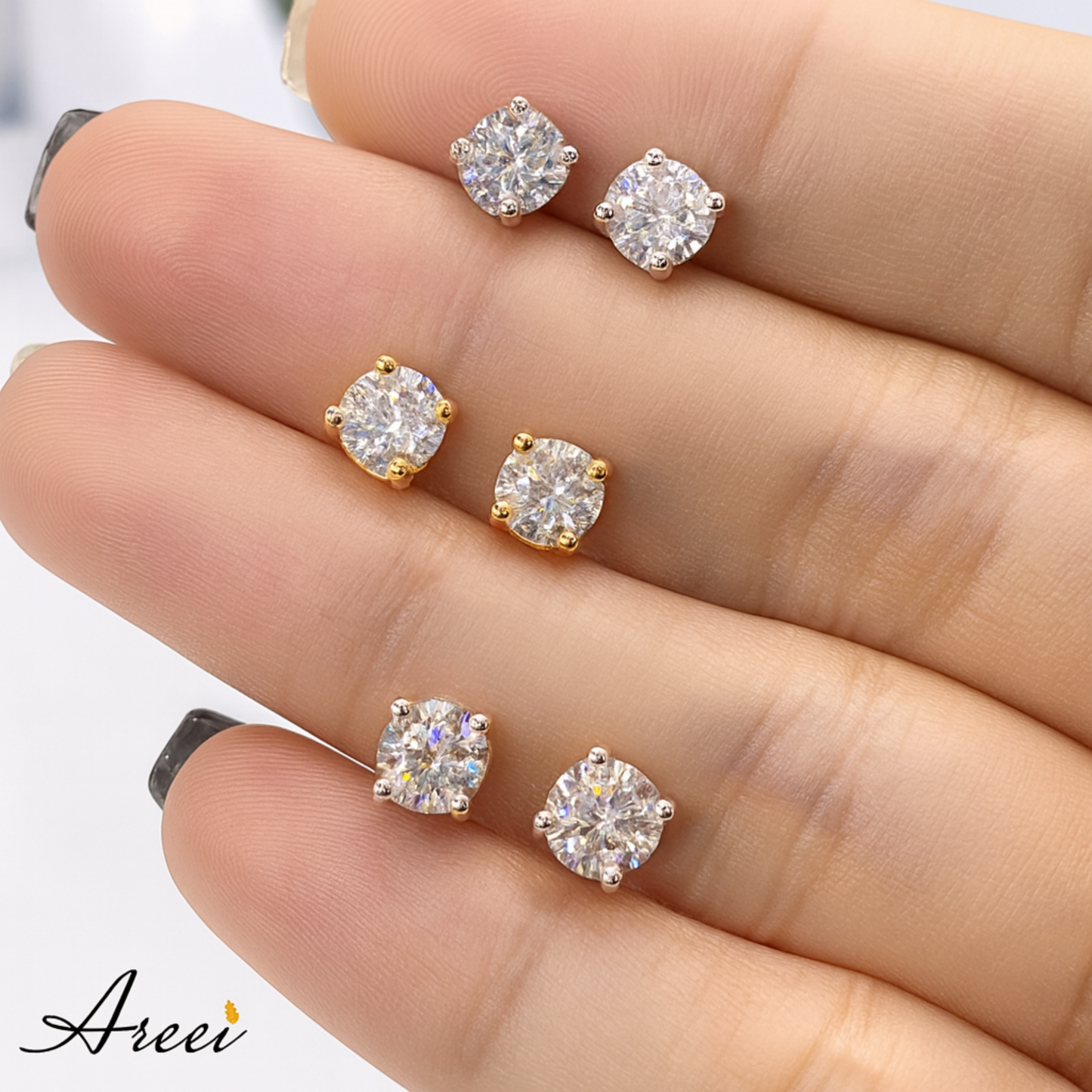 Diamond stud earrings on a hand with 'Areei' branding.