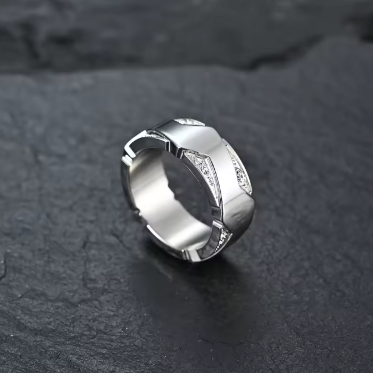 Silver ring with geometric design on a dark textured surface