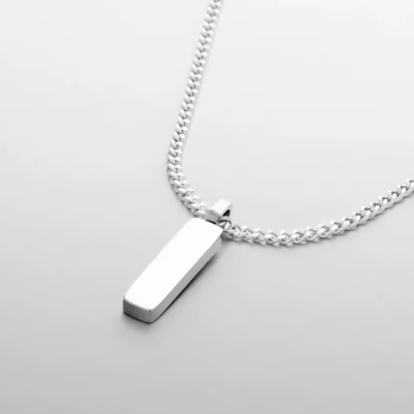 Silver necklace with a pendant on a light gray background