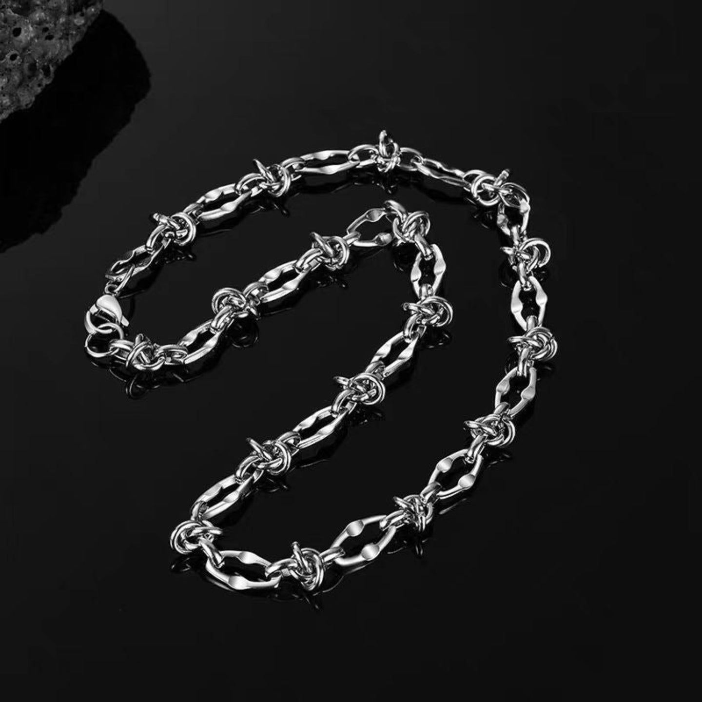 Silver chain necklace on a black background