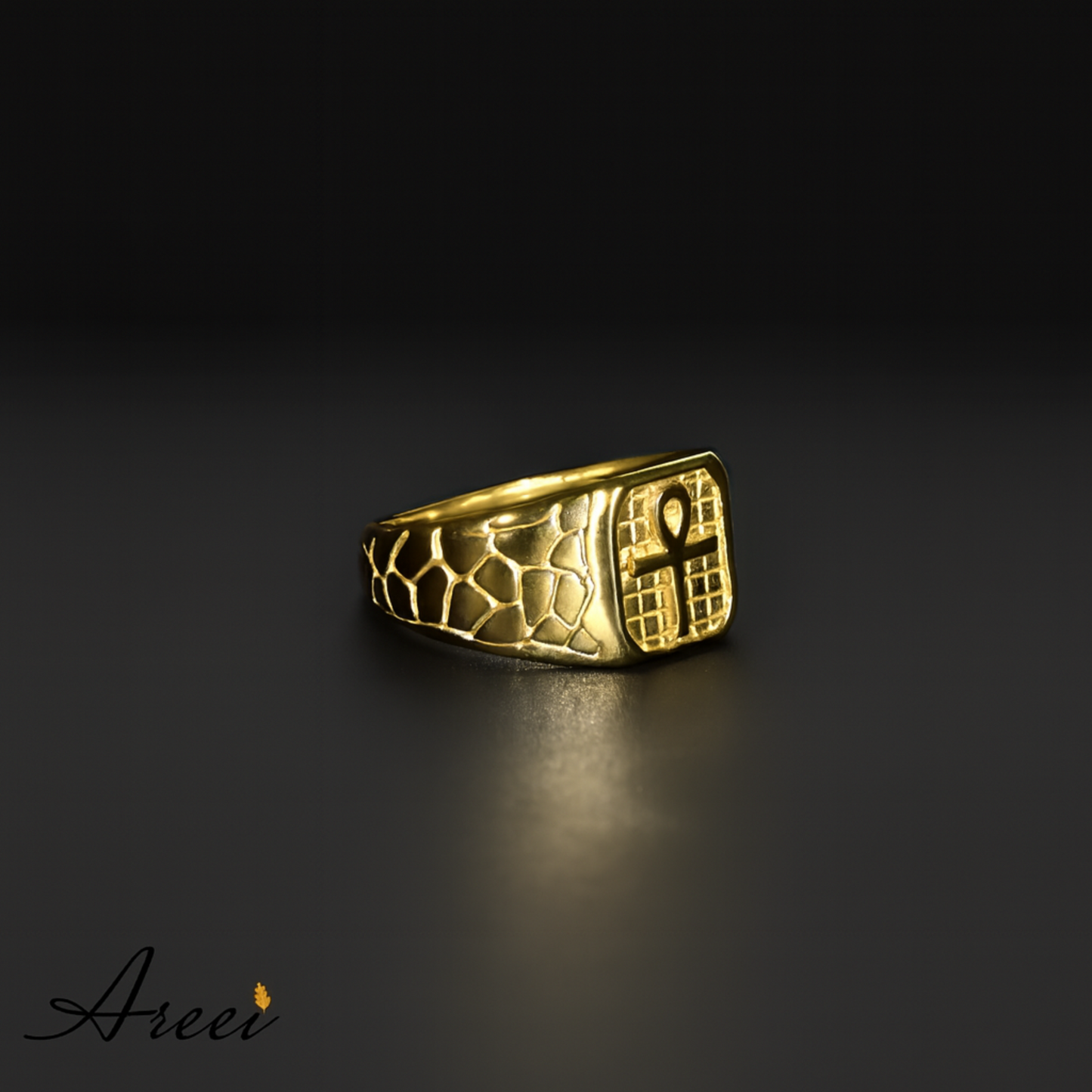 Gold ring with intricate design on a dark background