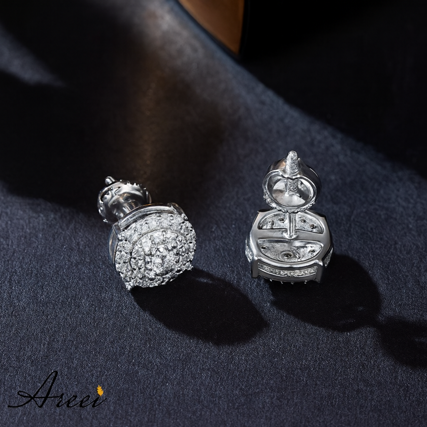 Pair of silver earrings with clear stones on a dark fabric background