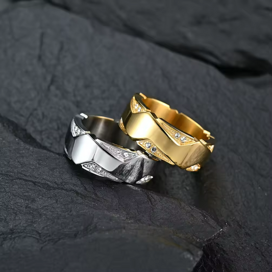 Gold and silver rings with diamond accents on a dark stone surface