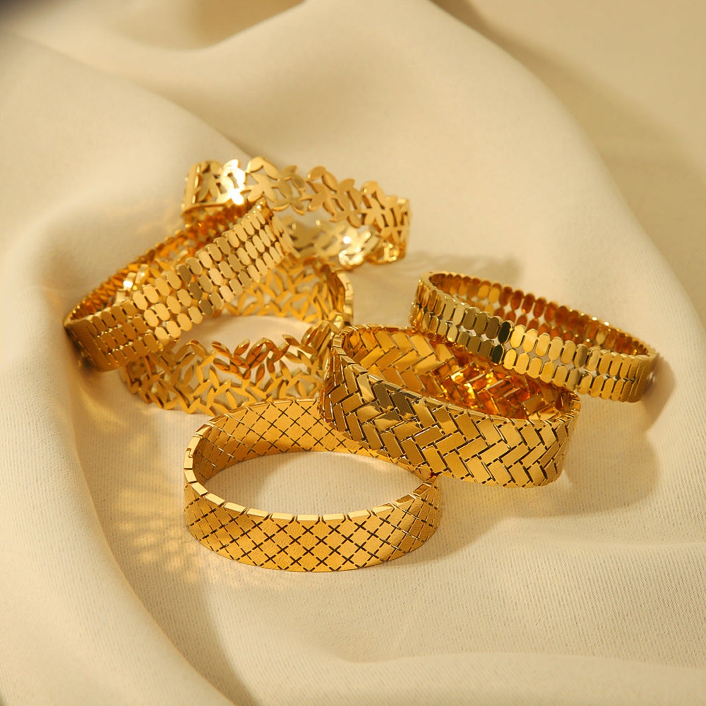 Gold bracelets on a beige fabric background