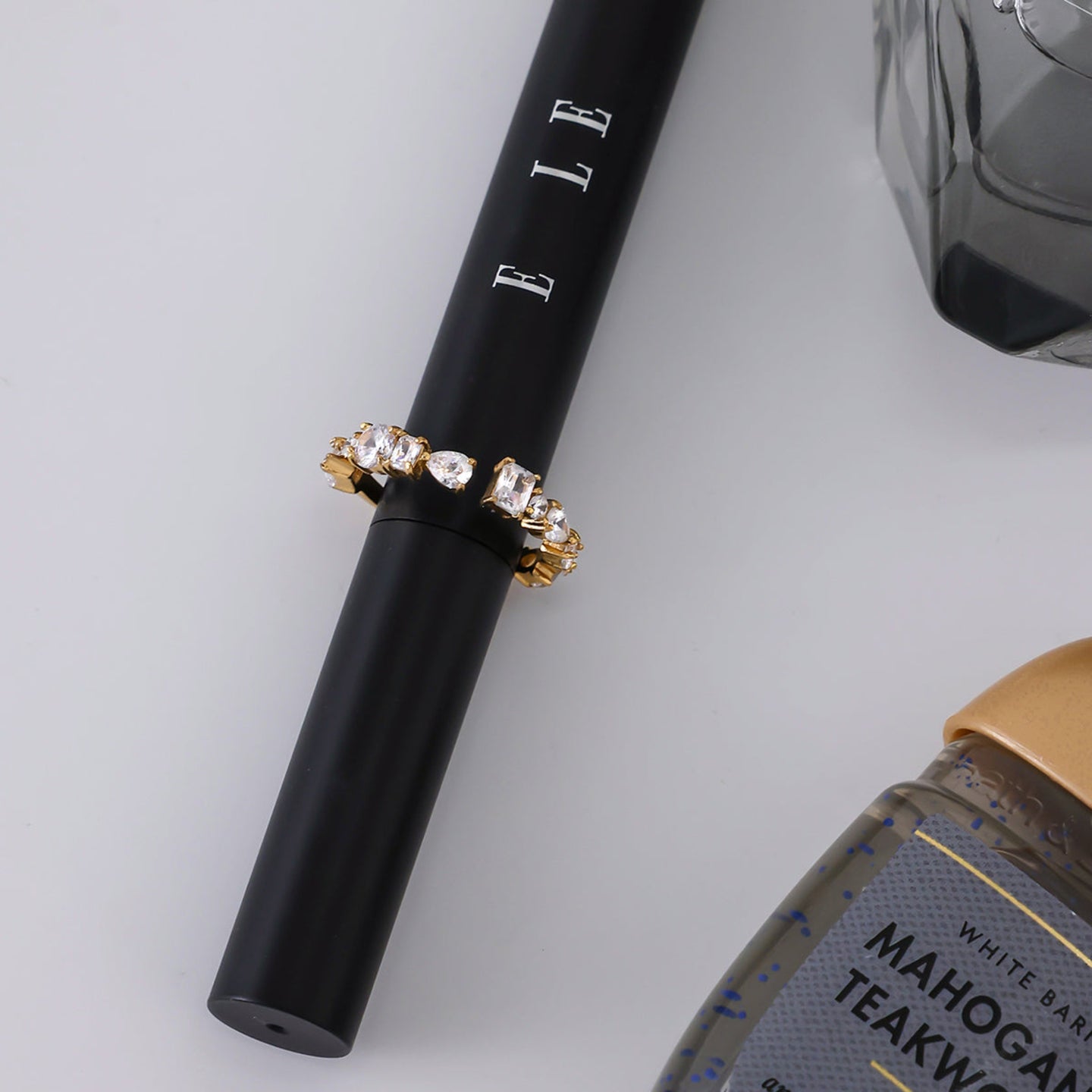 Black pen with decorative cap and bottle of white wine on a light gray background