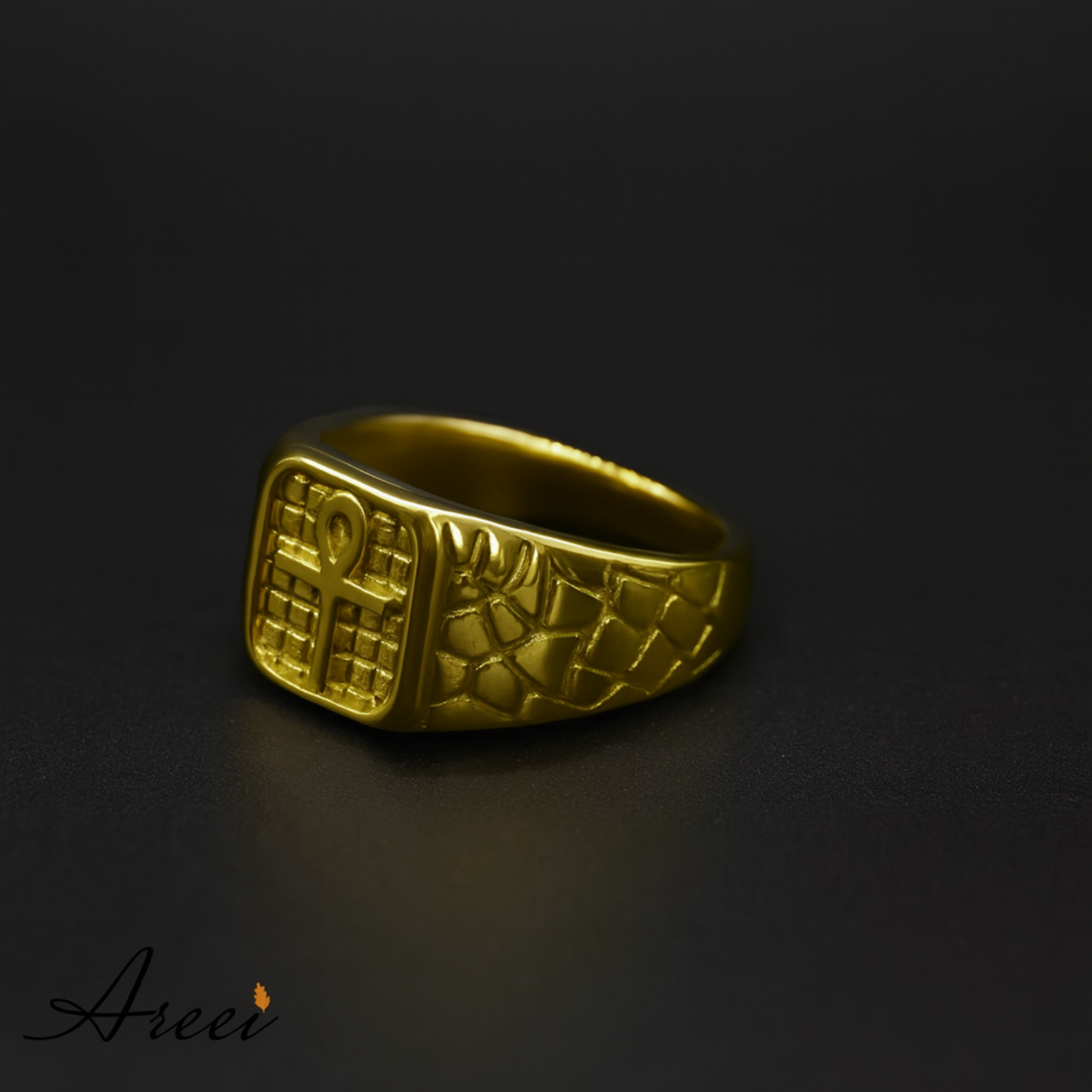 Gold ring with intricate design on a dark background