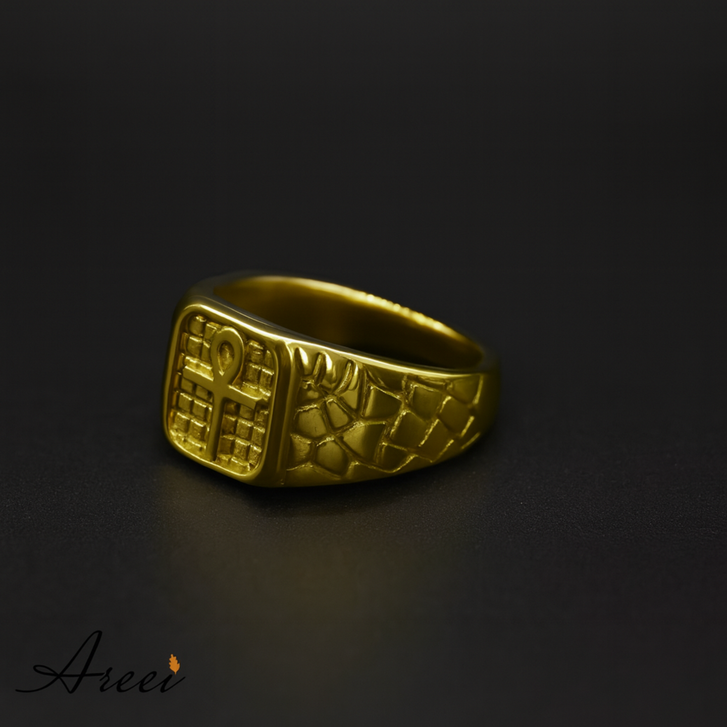 Gold ring with intricate design on a dark background