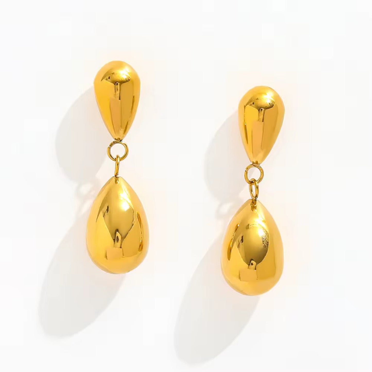 Pair of gold teardrop earrings on a white background