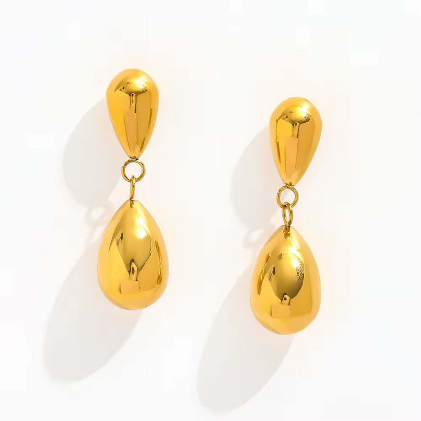 Pair of gold teardrop earrings on a white background