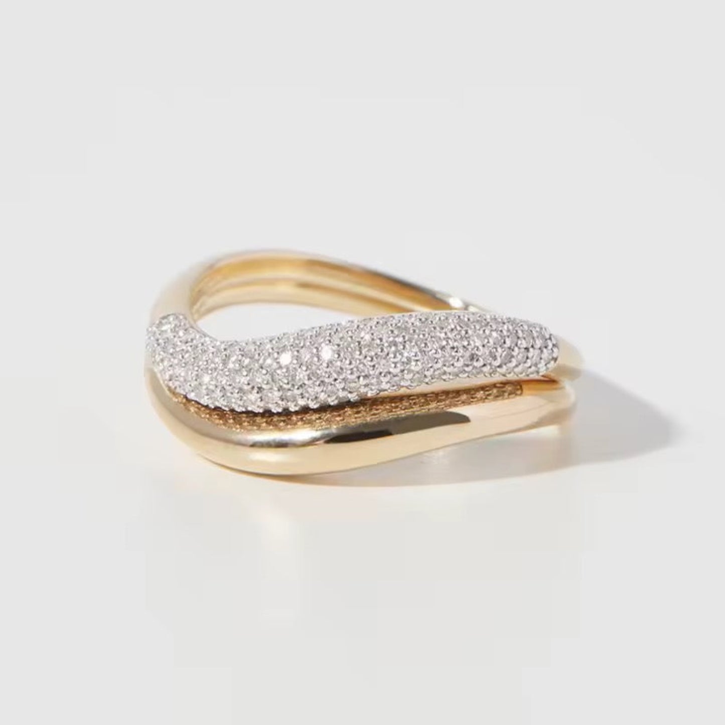 Gold and silver ring on a light gray background