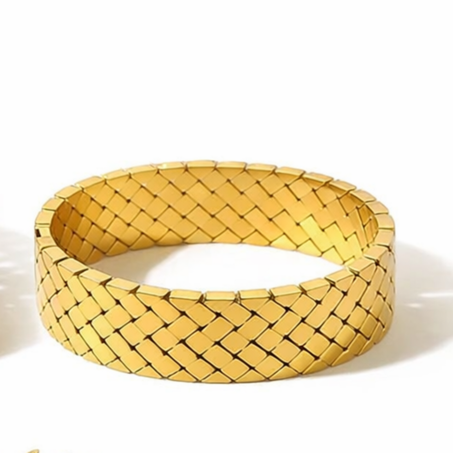 Gold woven bracelet on a white background