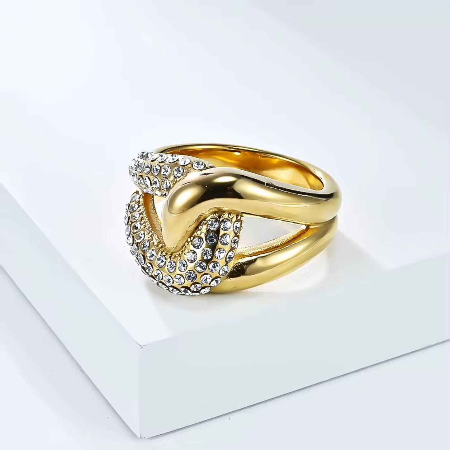 Gold ring with crystal embellishments on a white background