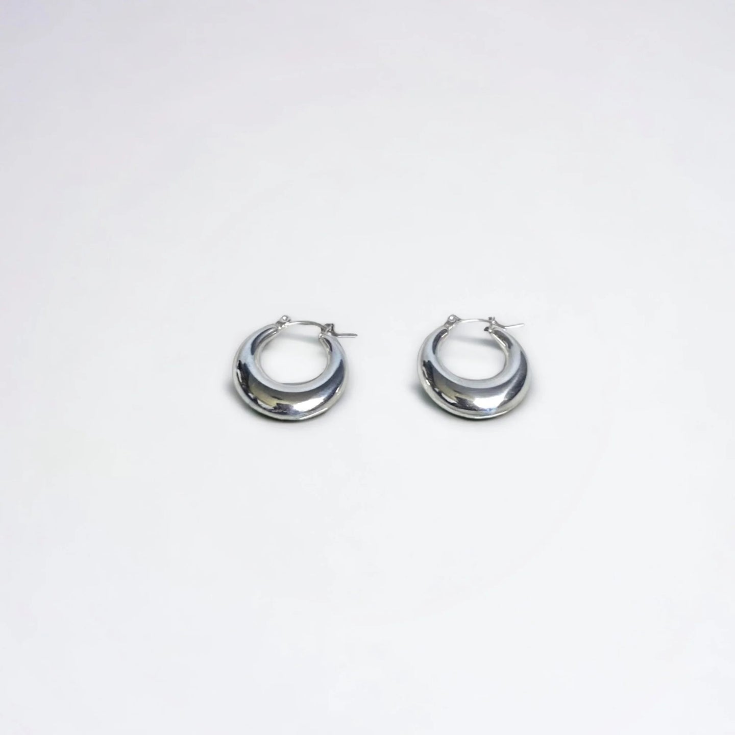 Silver chunky mini hoops on white background