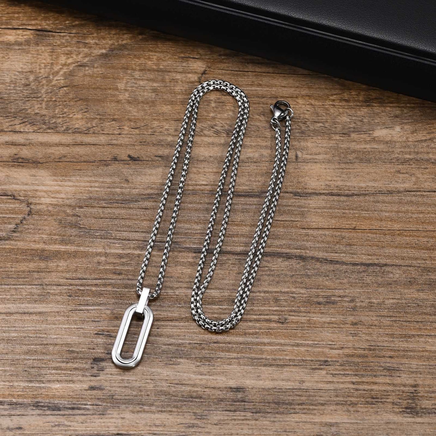 Silver chain necklace with a tag on a wooden surface