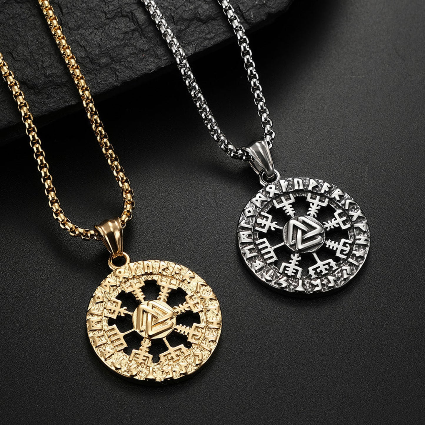Two necklaces with intricate pendants on a dark background
