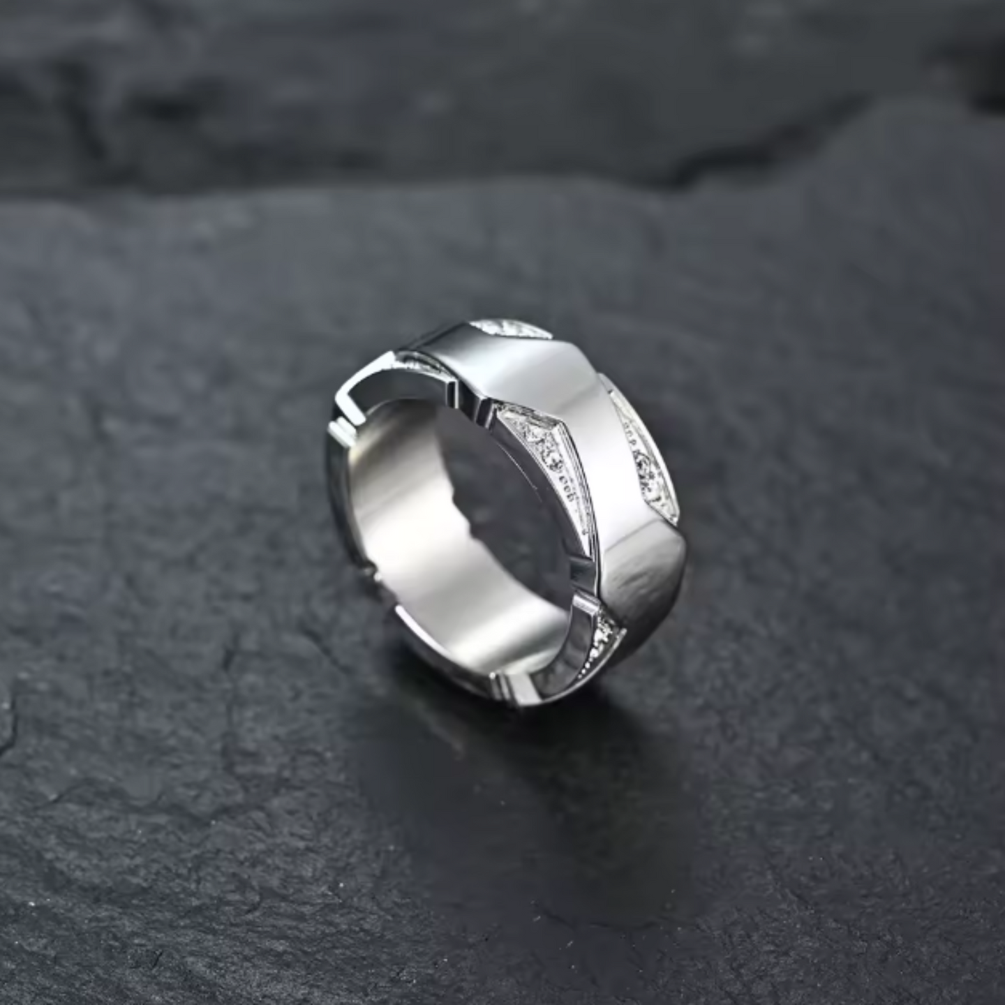 Silver ring with geometric design on a dark textured surface