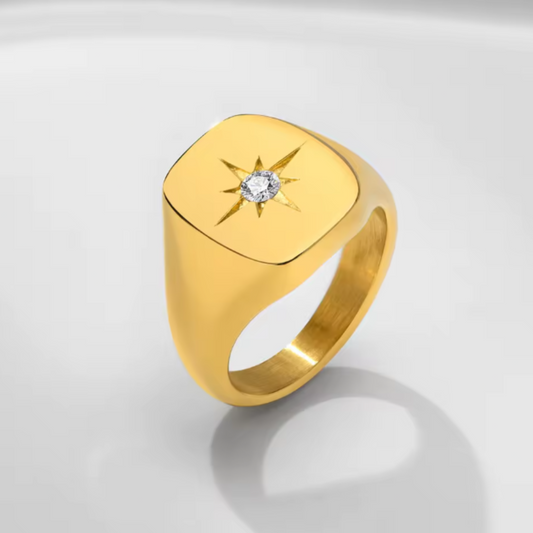 Gold ring with a diamond on a light gray background