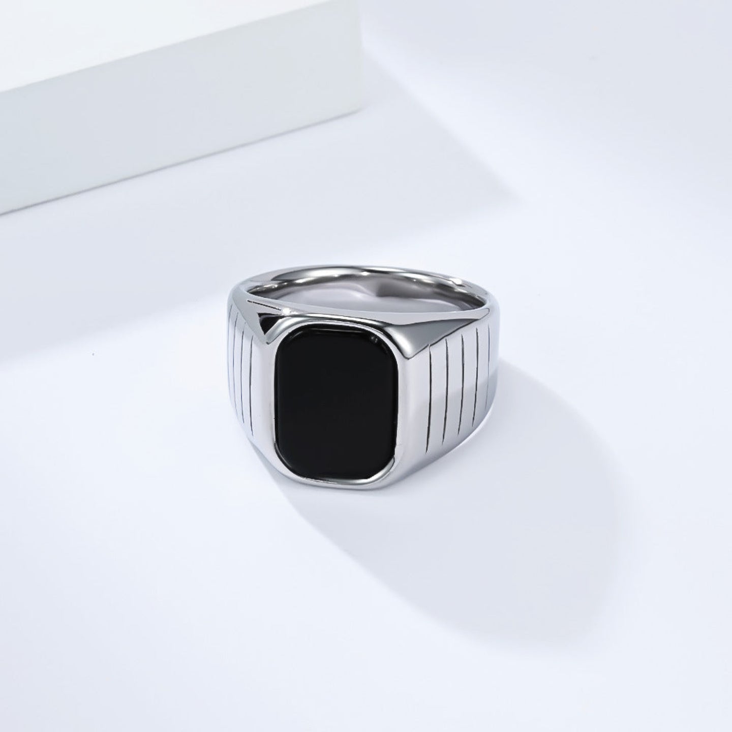 Silver ring with a black stone on a white background