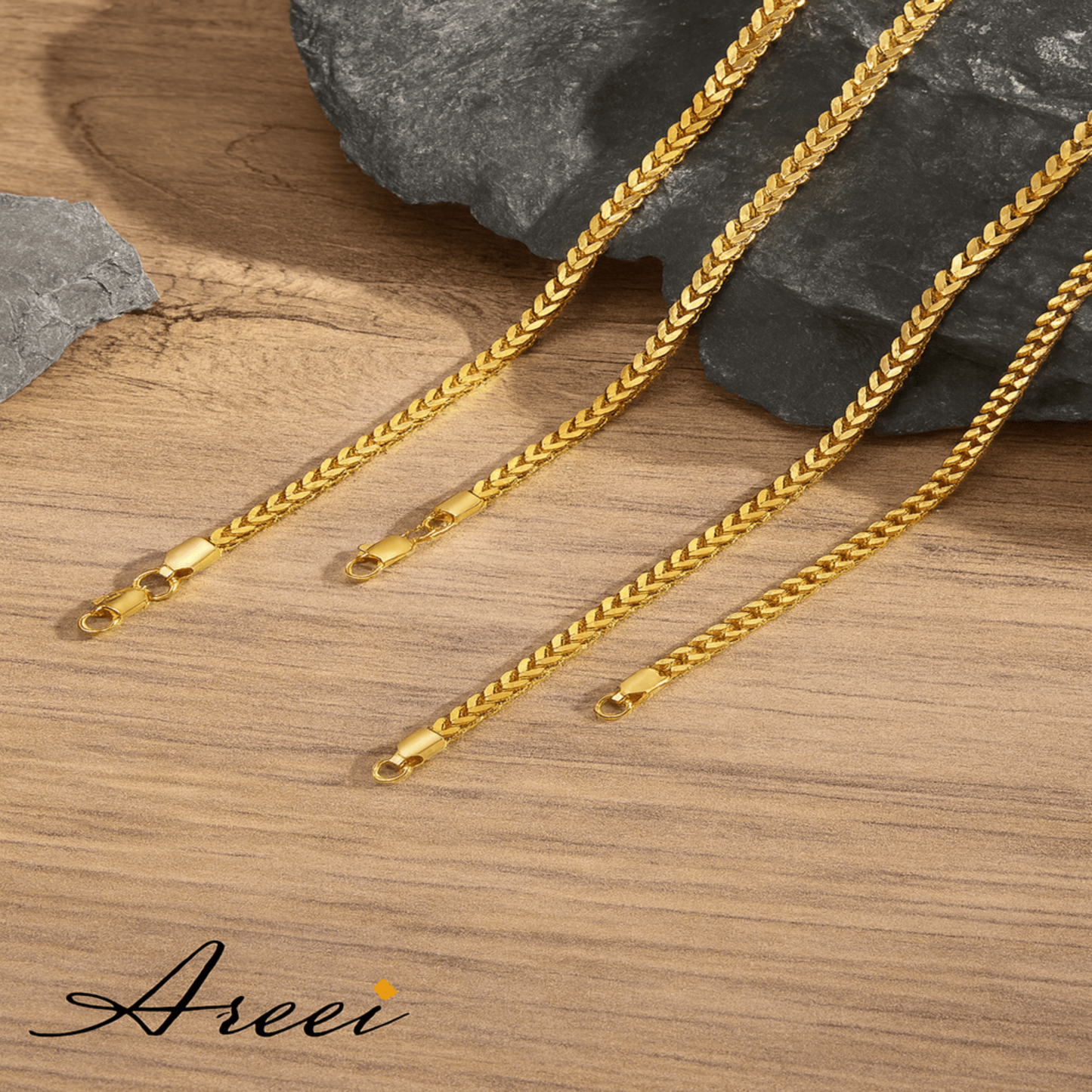 Gold chains on a wooden surface with 'Areei' branding.
